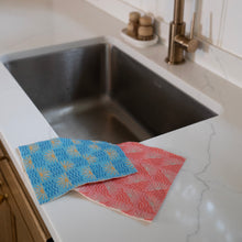 Load image into Gallery viewer, Two reusable cleaning cloths on a kitchen counter next to a sink.